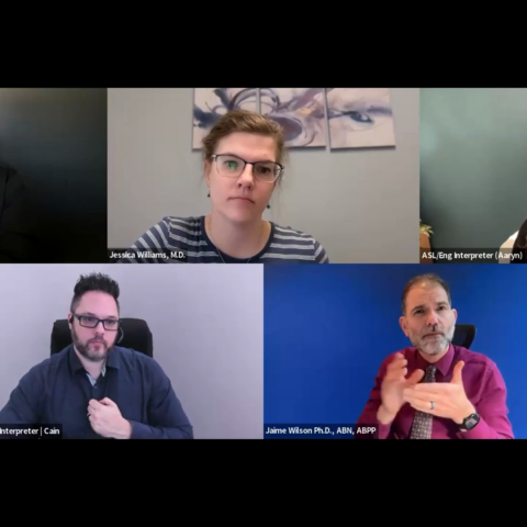 A screenshot of a virtual panel discussion shows five participants in a grid layout against solid or neutral office backgrounds. The top row features moderator Corey Axelrod, panelist Jessica Williams, M.D., and an ASL/English interpreter named Aaryn, while the bottom row shows an interpreter named Cain and panelist Jaime Wilson, Ph.D., who is actively signing.